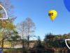 Yellow Hot air balloon rising over Lake Burley Griffin in Canberra
